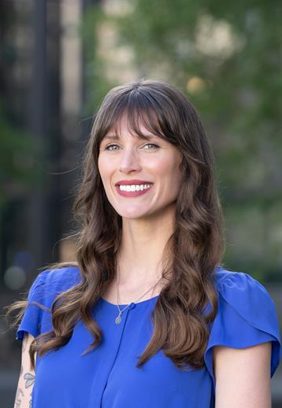 A white woman with brown hair wearing a blue shirt