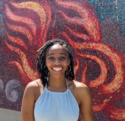 HCC Counseling intern Carmyn Hayes in front of wall mosaic
