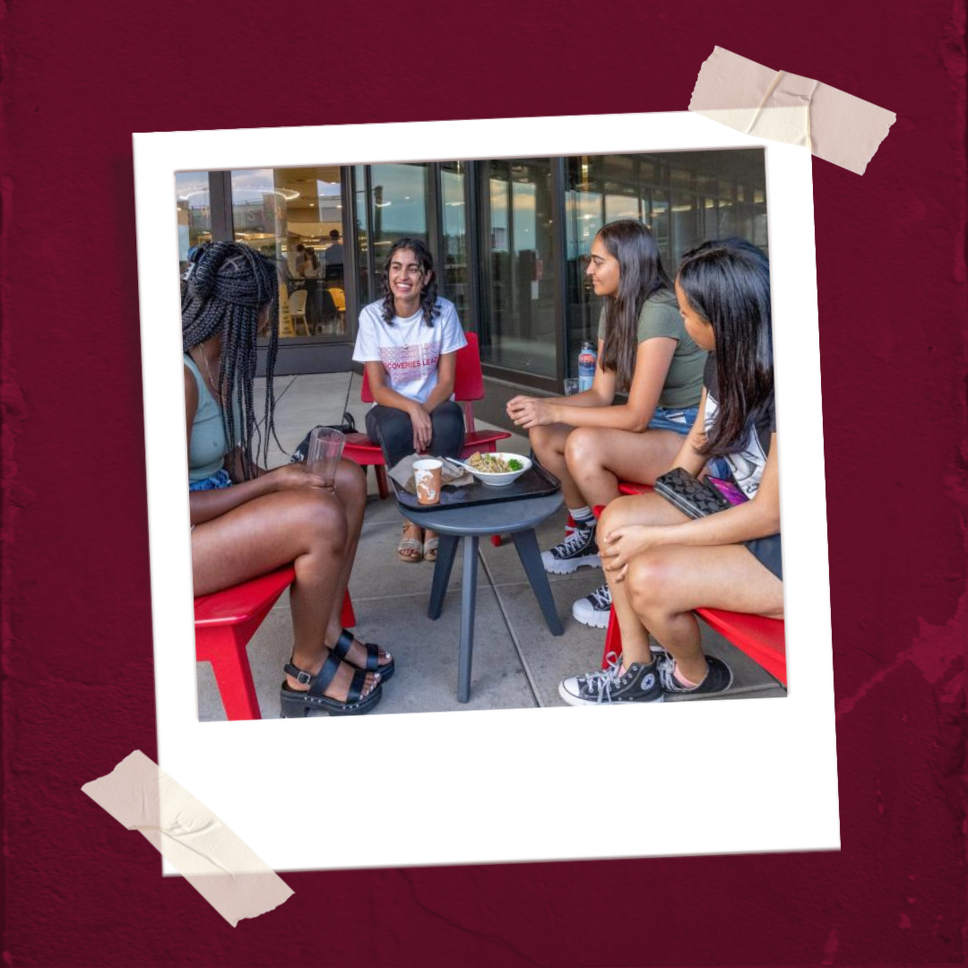 A polaroid of A group of students sits in a circle laughing and talking 