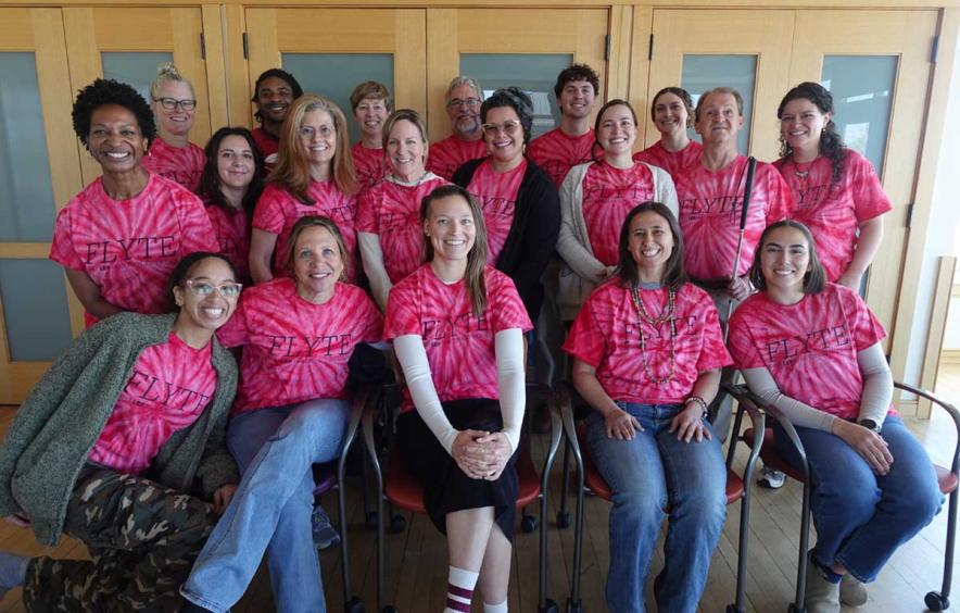 group photo of FLYTE team members all wearing pink FLYTE t-shirts