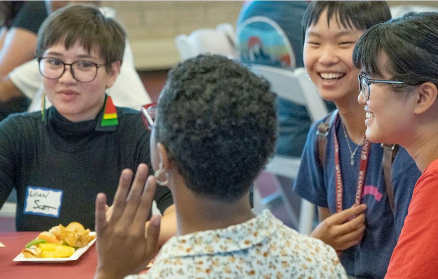 DU students enjoying a laugh over lunch at dining hall