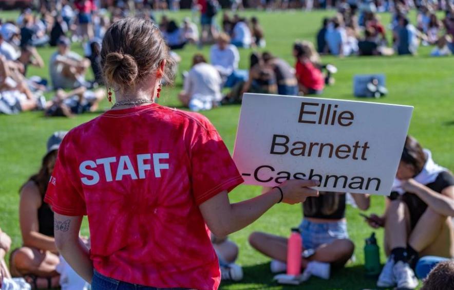 A 4D Peer Mentor holding a sign
