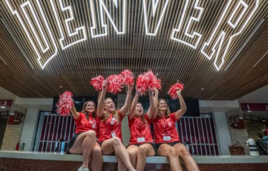 students in front of a University of Denver sign