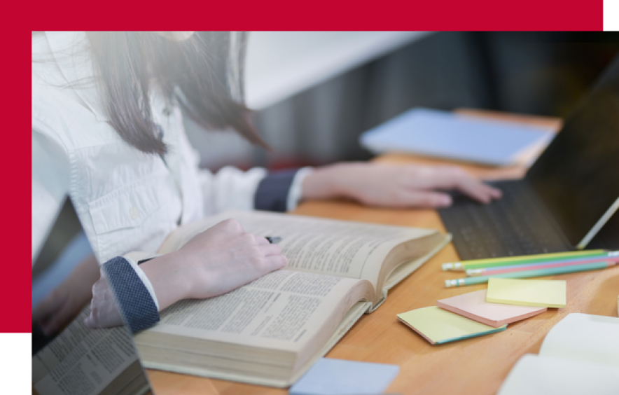 A student studies with a computer and textbook open.