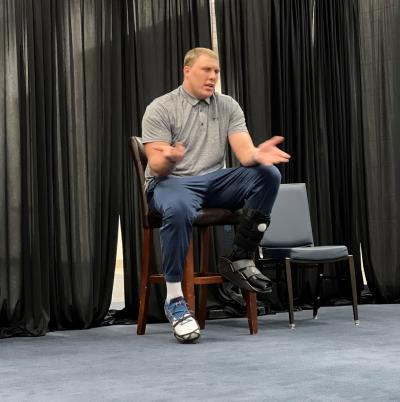 photo of garett bolles sitting on a stool presenting to a crowd