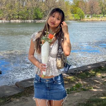 Photo of a woman holding flowers in front of a lake