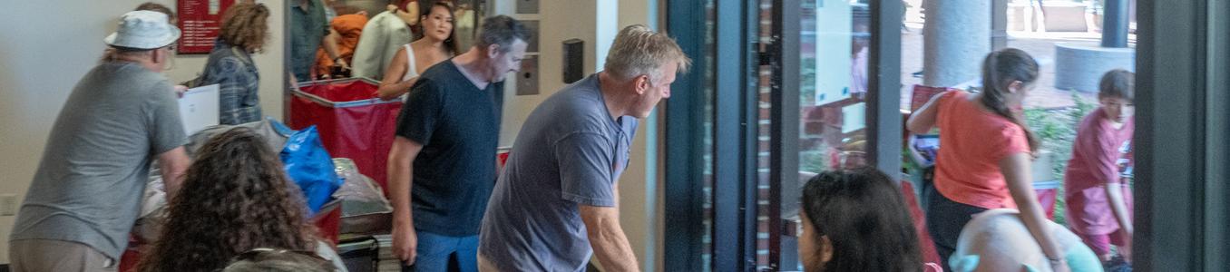 families move rolling bins during move in day to the DU dorms